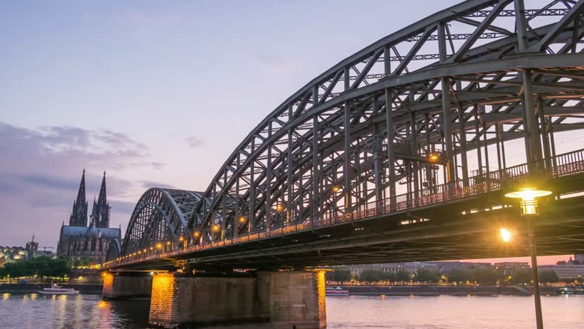 The hohenzollern bridge spans the rhine river in cologne at dusk