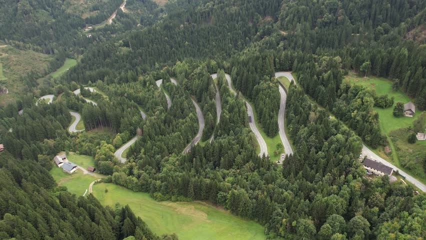 Alpine road in Austrian Alps, Aerial scenic view of winding mountain road into forest, point of interest shot