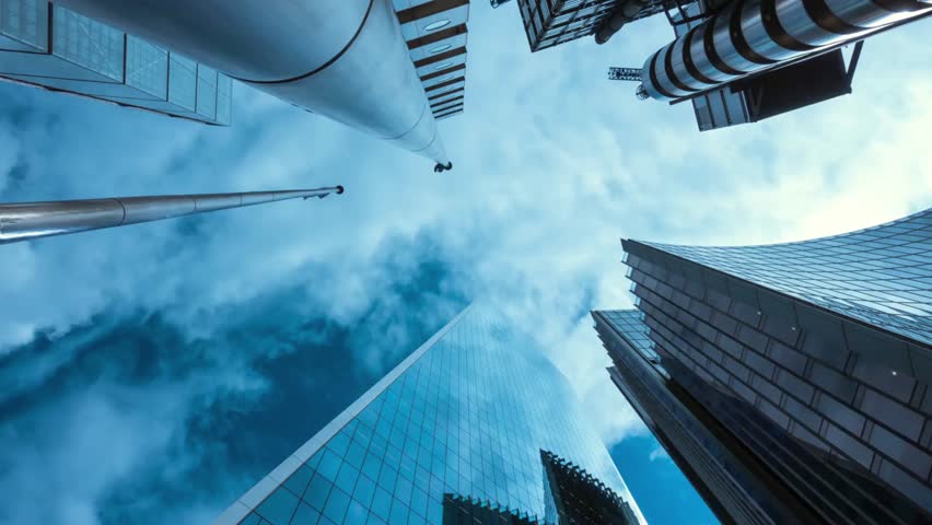 Looking up at modern skyscrapers against a cloudy blue sky in the city