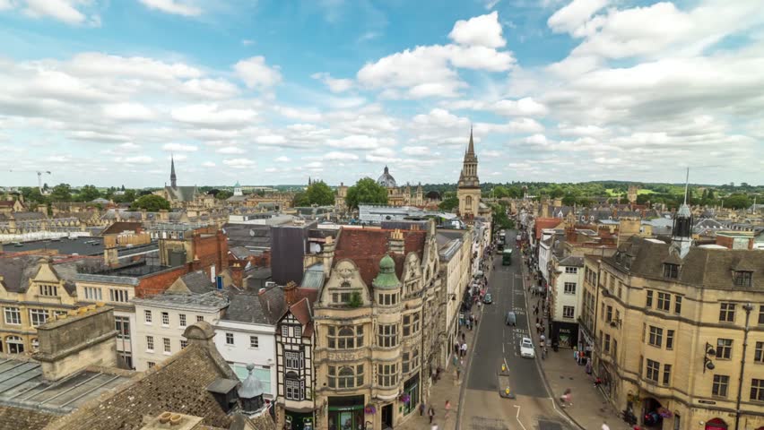 An aerial view captures the cityscape of oxford on a bright, cloudy day