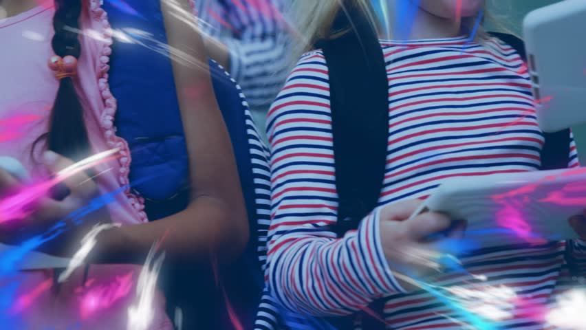 Schoolchildren raising tablets in classroom, comparing screens, sharing info with pink-blue lights. Education, technology, collaboration, digital, learning, youth, classroom - Powered by Shutterstock - Get 15% off with code: PIKWIZARD15