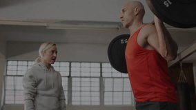Gym trainee squatting under barbell causing candlesticks rising % labels and coach adjusting form. Fitness, training, strength, performance, analytics, motivation, health - Powered by Shutterstock - Get 15% off with code: PIKWIZARD15
