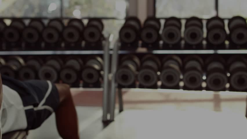 Male lifter gripping dumbbell initiating bench press for fitness tracking with graph overlays. Strength training, gym equipment, fitness, digital analytics, workout, athletic, exercise