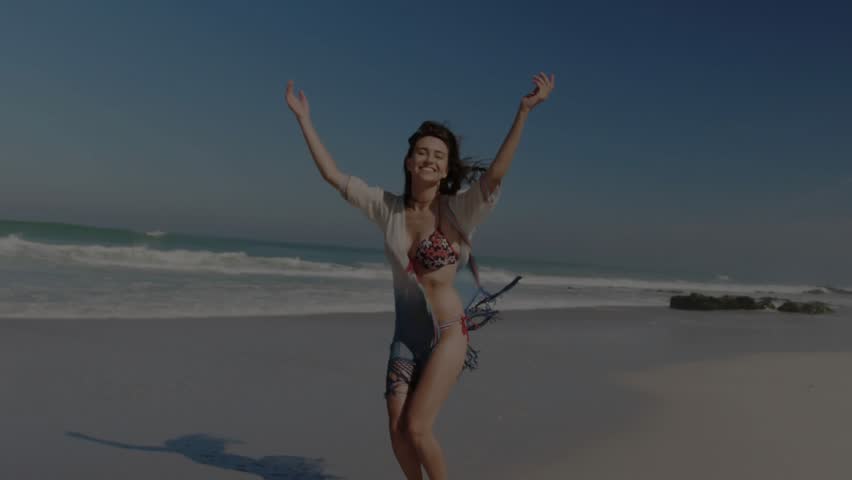 Woman dancing and walking toward camera on beach starting globe showing connectivity in technology. Fitness, wellness, vitality, wanderlust, leisure, serenity, digital - Powered by Shutterstock - Get 15% off with code: PIKWIZARD15
