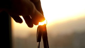 A closeup silhouette of one hand giving keys to another against a golden sunrise. A concept for buying a new home, car, or success. - Powered by Shutterstock - Get 15% off with code: PIKWIZARD15