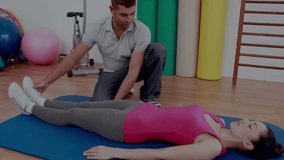 Trainer reaching for client ankle and guiding knee flexion on blue mat for rehabilitation stretch. Physiotherapy, flexibility, rehabilitation, exercise, stretching, fitness, health - Powered by Shutterstock - Get 15% off with code: PIKWIZARD15