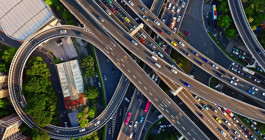 Aerial shot of a multi-level highway interchange with busy vehicle traffic creating a complex urban transportation network in Guangzhou, China.