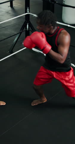Above, punch and men with gloves in boxing ring, strength and cardio training in practice match. Intense, skill development and people kickboxing with power in gym, fitness or endurance in fist fight
