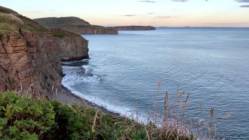 Scenic coastal landscape at sunset with rugged cliff edge