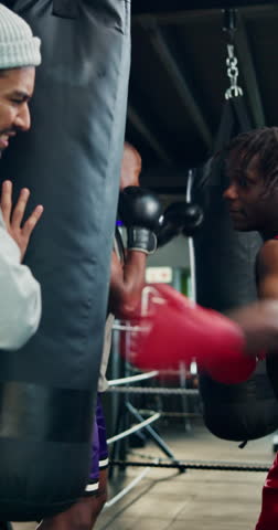 Boxing bag, personal trainer and fitness with men in gym for combat sports, martial arts and workout. Self defense exercise, mma training and punch with people in club for coaching and fight