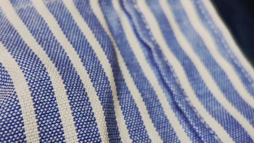 Macro photo of textured blue and white striped textile, showing woven fibers, patterns, and thread details; fashion, design, texture, and clothing material aesthetics