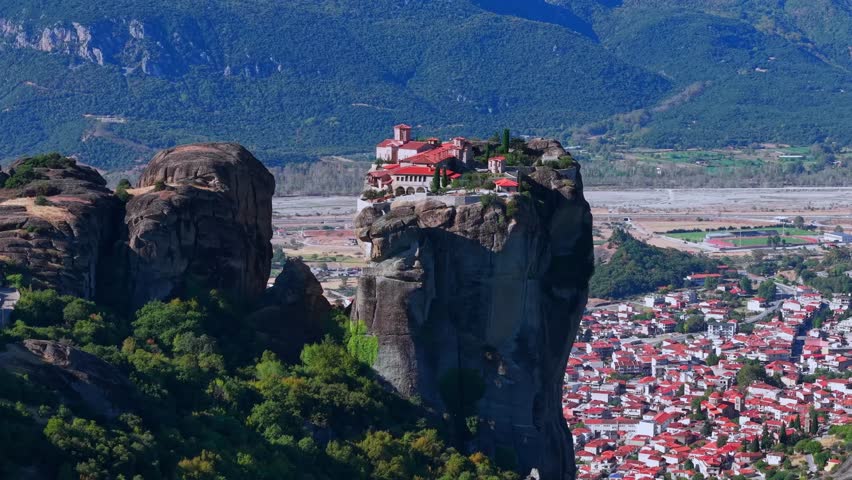 Aerial View of the Great Meteoron Monastery atop Towering Rock in Meteora and town houses of Kalambaka, Greece