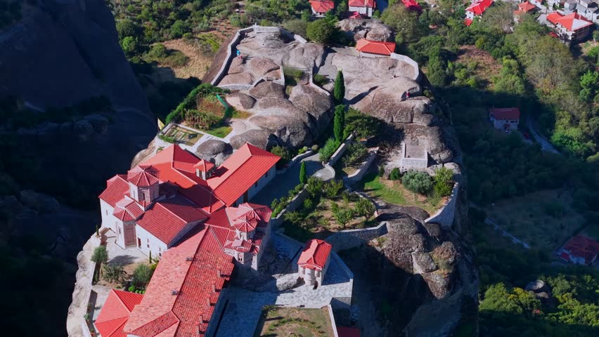 Aerial View of the Great Meteoron Monastery atop Towering Rock in Meteora and town houses of Kalambaka, Greece