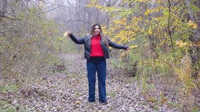 autumn style. Woman in red sweater and black leather jacket dancing in yellow forest enjoying the season gathering the leaves - Powered by Shutterstock - Get 15% off with code: PIKWIZARD15