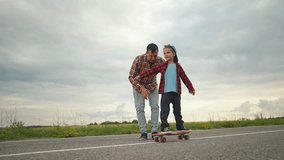 Father son enjoying skateboarding together outdoors: Father helps son balance on skateboard outdoors. Kid practicing skateboarding father support. Family bonding over outdoor skateboarding activity. - Powered by Shutterstock - Get 15% off with code: PIKWIZARD15