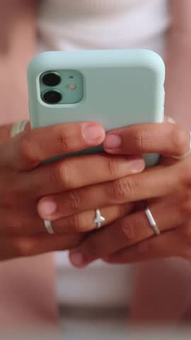 Closeup of hands holding a smartphone with mint case texting and scrolling on a mobile device, female hands with rings and manicured nails in a casual setting. Technology, communication, lifestyle
