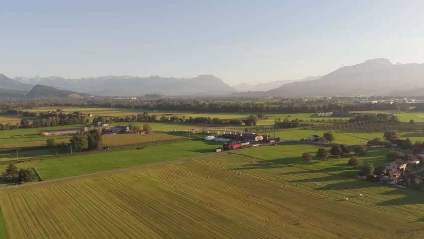 Drone advances over Marchbach croplands with Alps beyond. Aerial