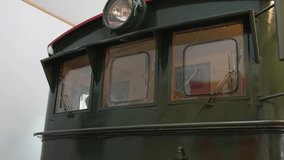 Camera pan down inside Flåm Railway Museum, Norway, revealing the front of a vintage green locomotive and its preserved industrial detailing. - Powered by Shutterstock - Get 15% off with code: PIKWIZARD15