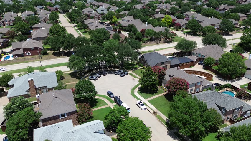 Residential cul-de-sac dead-end in Coppell, Texas, featuring two-story suburban homes, fenced yards, swimming pools, tree-lined streets leading toward Cottonwood Creek Elementary School campus. USA