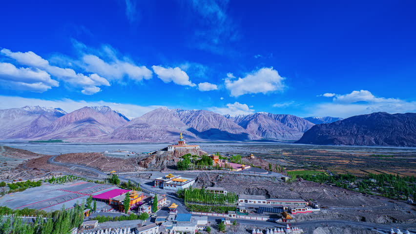 The sacred Diskit Monastery statue stands tall on a mountaintop in the vast valley Himalayas. Diskit Gompa is the oldest and largest Buddhist monastery in the Nubra Valley of Ladakh, northern India.