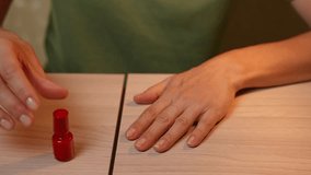 Woman painting her nails red at home, applying smooth coats with precise brush strokes for a classic manicure. Hand care at home. Manicure at home - Powered by Shutterstock - Get 15% off with code: PIKWIZARD15