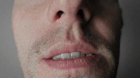 Extreme macro shot of lower part of man's face, showing lips pulling back to reveal white teeth in a grimace. Unshaven stubble and detailed skin texture are visible around the tense mouth area. - Powered by Shutterstock - Get 15% off with code: PIKWIZARD15