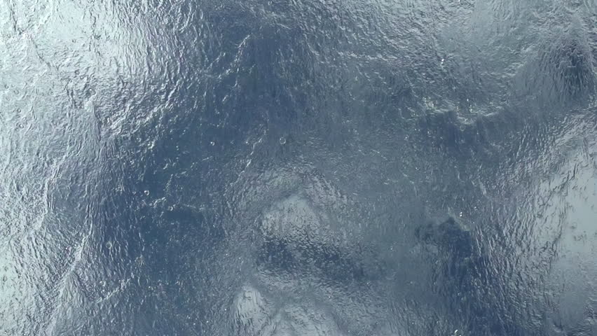The Flow of Clean Water. Water flows down the glass on a background of white clouds and blue sky. Slow Motion