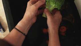 Hands are shown rinsing fresh vegetables under running water in a kitchen sink. - Powered by Shutterstock - Get 15% off with code: PIKWIZARD15