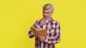 Mature man focuses intently on open book, revealing stunned curiosity perplexed gaze. Middle-aged guy on yellow background exhibits amazed wow reaction, hinting at new revelations hidden in text - Powered by Shutterstock - Get 15% off with code: PIKWIZARD15