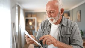 Overjoyed senior man reading a letter with good news, celebrating a personal victory at home. His initial concentration turns into pure happiness as he understands the positive outcome - Powered by Shutterstock - Get 15% off with code: PIKWIZARD15
