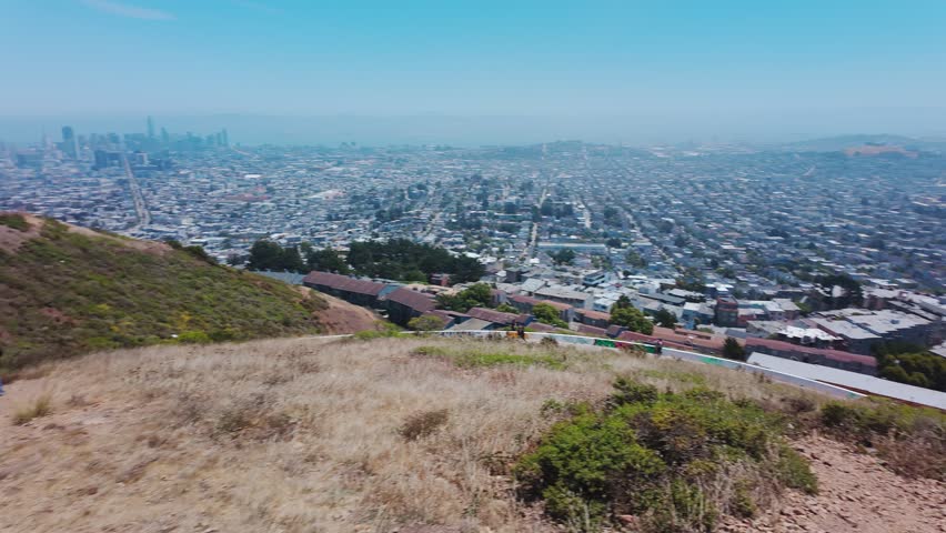 Panoramic cityscape of San Francisco seen from Twin Peaks, California, USA. Wide view of urban skyline, residential neighborhoods and bay under clear summer sky