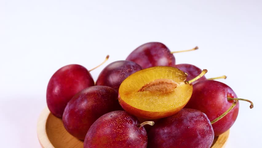 Fresh plums on a plate, rotating