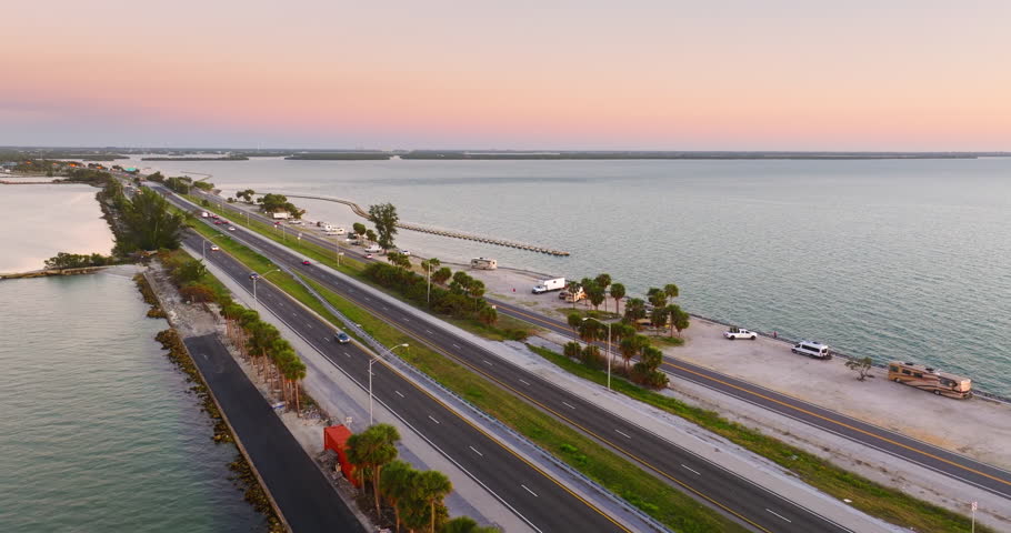 RV campers parked at sunset near Sunshine Skyway Bridge over Tampa Bay in Florida. Transportation infrastructure in America.