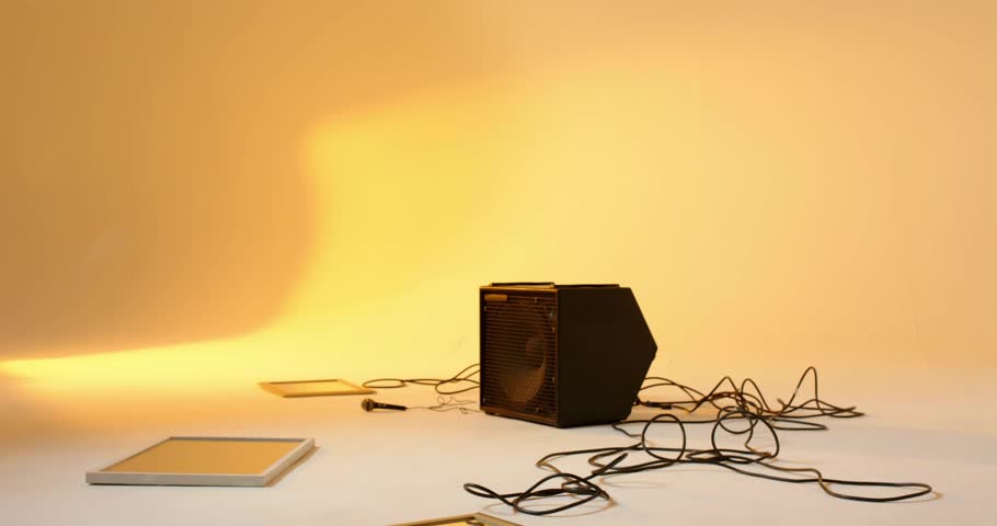Mid adult man stepping onto lit studio panel and shuffling into foot tapping dance around speaker. Urban, performance, rhythmic, dynamic, contemporary, minimalist, entertainment