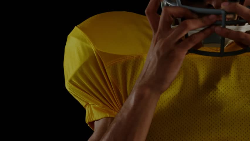 Football player lifting helmet and securing chinstrap, adding encrypted code visuals for security. Athlete, cybersecurity, digital, technology, futuristic, performance, determination