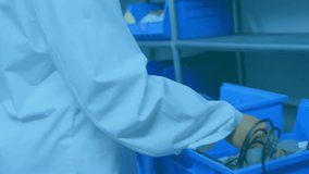 Lab technician reaching blue bins and activating overlays, selecting parts and analyzing systems. Technology, innovation, precision, research, futuristic, science, data - Powered by Shutterstock - Get 15% off with code: PIKWIZARD15