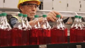 Operator tapping tablet scanning bottles with live graphs displaying quality data on bottling line. Industrial, manufacturing, technology, quality, automation, analytics, safety - Powered by Shutterstock - Get 15% off with code: PIKWIZARD15