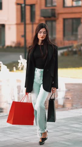 Young woman enjoys shopping in a stylish outfit by a modern fountain area