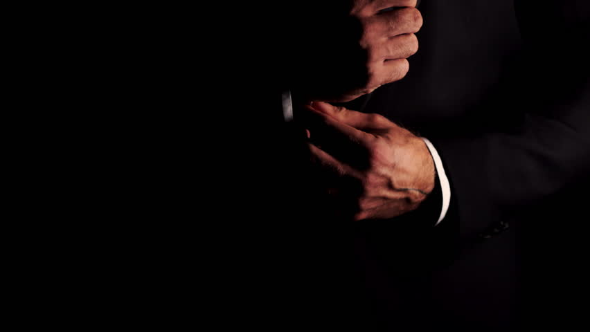 Close-up of a male businessman in a suit adjusting his shirt cuff. An elegantly dressed man adjusts his cufflinks. The groom adjusts the cufflinks on his shirt. 