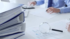 Business team working with financial data using laptop and magnifying glass, analyzing charts and checking reports, close up. Audit and taxes in business - Powered by Shutterstock - Get 15% off with code: PIKWIZARD15