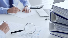 Business team working with financial data using laptop and magnifying glass, analyzing charts and checking reports, close up. Audit and taxes in business - Powered by Shutterstock - Get 15% off with code: PIKWIZARD15