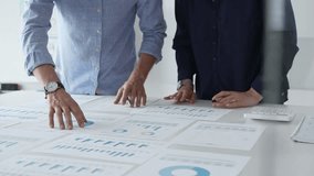 Professional team reviewing financial documents, pointing at charts on desk, collaborating to analyze data and strategize business growth. Business people concept - Powered by Shutterstock - Get 15% off with code: PIKWIZARD15