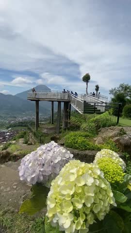 Dieng Sky Park glass bridge with Mount Sindoro and blue sky in the background