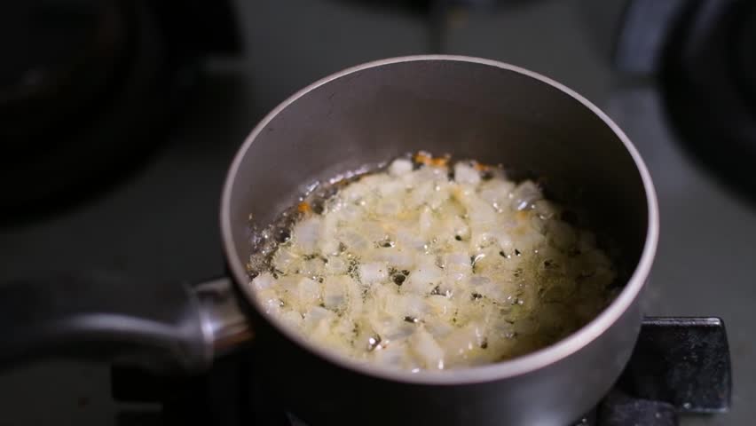 Caramelizing Onions in Frying Pan. Slow Motion Frying Onions in Pan. Frying Chopped Onions on Hot Pan.