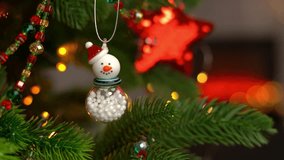Camera movement on white snowman on branch Christmas tree on background of shining lights of golden garland and fireplace. New Yea - Powered by Shutterstock - Get 15% off with code: PIKWIZARD15