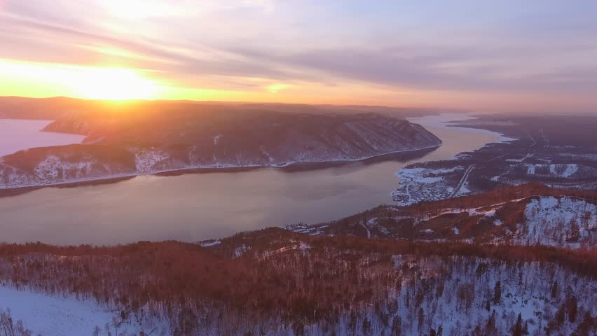 Helicopter epic winter Lake Baikal, Angara River. Golden sun rays over authentic Taltsy village, Zabaikalsky region. Snowy Siberian landscape, reflections in water, vast Russian wilderness. Landmark