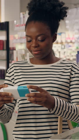 African American woman buying pills in pharmacy female customer read drugs vitamins instruction health care supplements antibiotic painkiller dosage disease symptoms in drugstore shopping medicine