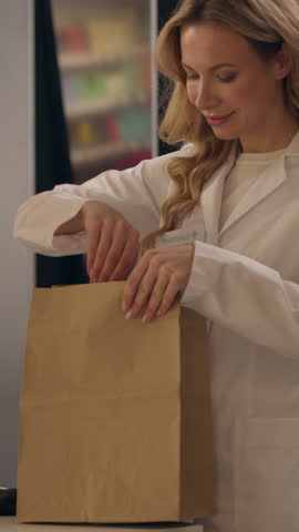 Pharmacy medication package woman doctor in coat pharmacist health care worker packing medicine order pills vitamins drugs in paper bag female Caucasian girl medical pharmacology assistant drugstore