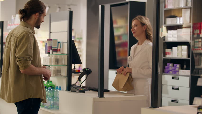 Pharmacist woman sell medicine in pharmacy cashier counter help customers buying medication health care service medical prescription drugstore order using contactless payment buy pills drugs vitamins
