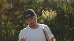 Whip pan of a young man in a white shirt and black cap practicing tennis on a hardcourt, surrounded by lush greenery. Dynamic motion highlights focused training, athleticism. - Powered by Shutterstock - Get 15% off with code: PIKWIZARD15